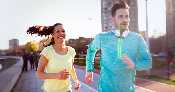 istock Young attractive couple running outside on sunny day 888215812
