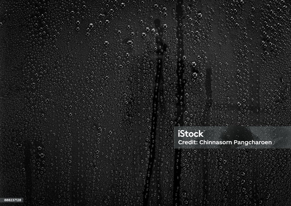 Rain drops pattern on glass Rain drops pattern on black glass surface for background and texture material Glass - Material Stock Photo