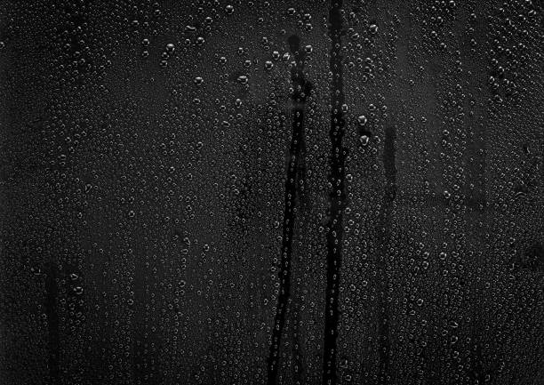 Rain drops pattern on glass Rain drops pattern on black glass surface for background and texture material black glass surface stock pictures, royalty-free photos & images