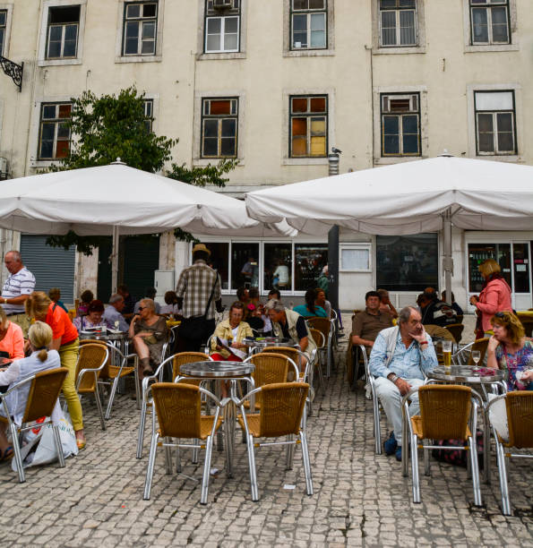 Customers relaxing at a  pavement cafe in the Praca da Figueira Lisbon
