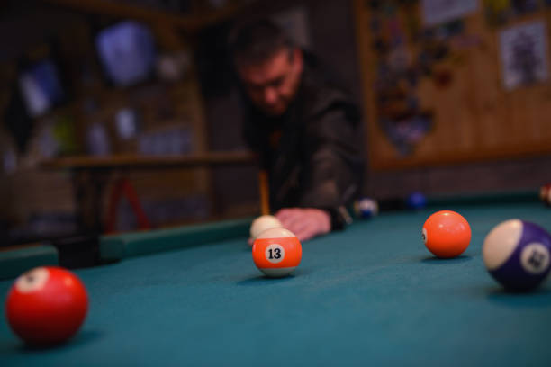 istock Serious man aiming at pool ball during billiard game 888243702