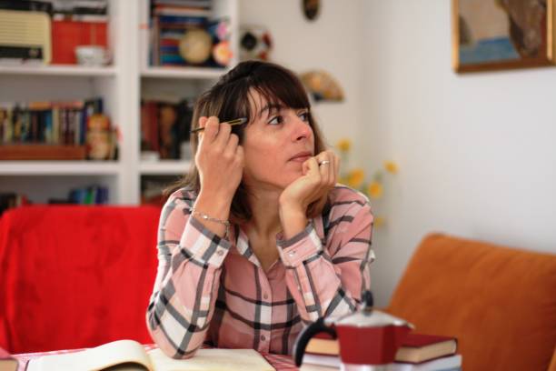 istock Thoughtful young woman writing a book 888251058