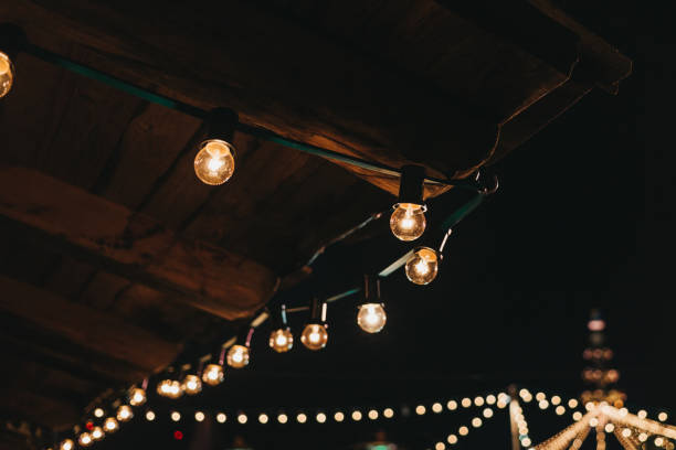 The string of vintage lights bulbs outside at night, lights on the background, selective focus