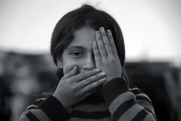 Photo of syrian girl showing one eye, mouth closed