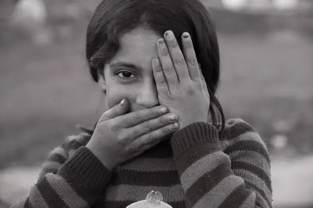 Photo of syrian girl showing one eye, mouth closed