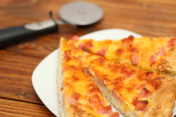 istock Pizza on plate with cutter on wood table 888342420