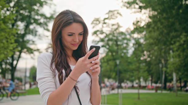 istock A Beautiful Brunette Using a Mobile Phone Outdoors 888343290