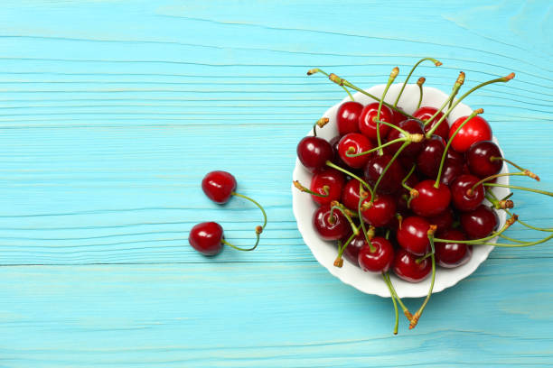istock cherry in bowl on blue wooden background. Top view with copy space. 888343382