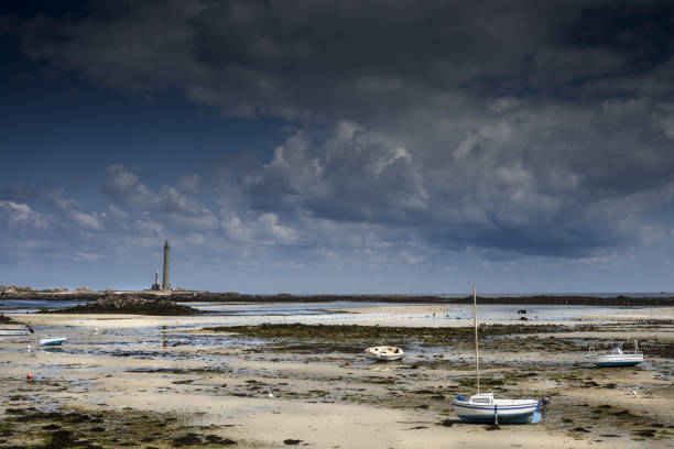 береговой ландшафт во время отлива с маяком и сушеными лодками в бретани, франция, guisseny - buoy anchored sea wave стоковые фото и изображения