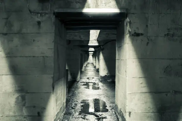 Photo of Long corridor between the straight concrete walls of a submarine bunker in St Nazarre, France.