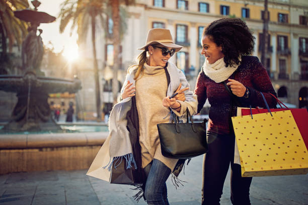 istock Happy girlfriends are walking on the town square with fountain after shopping 888368708