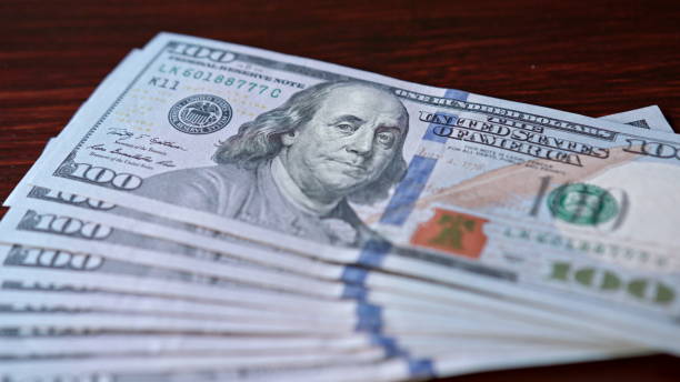 istock Fanned Pile of Hundred Dollar Banknotes on a Table 888382776