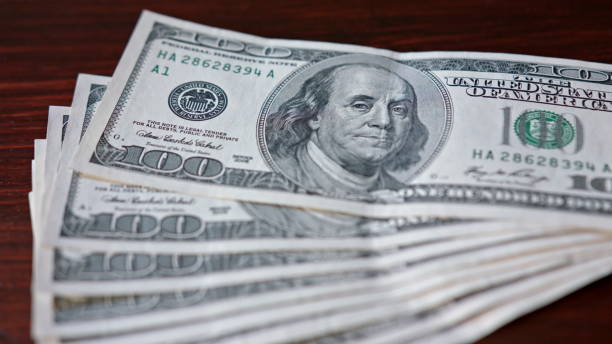 istock Fanned Pile of Hundred Dollar Banknotes on a Table 888382912