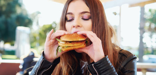istock Girl eating a hamburger 888403228
