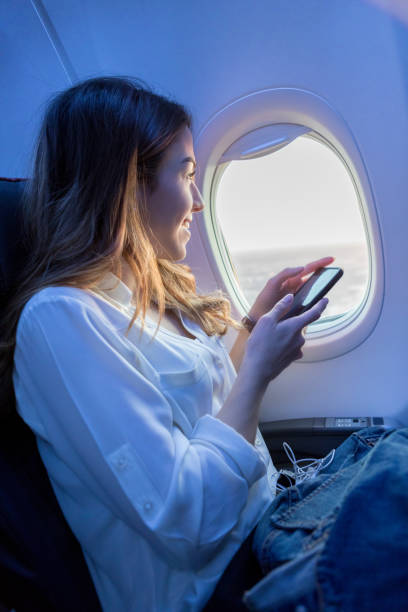 jeune femme avec vue horizon de siège côté fenêtre d’avion - people traveling business travel travel new york city photos et images de collection