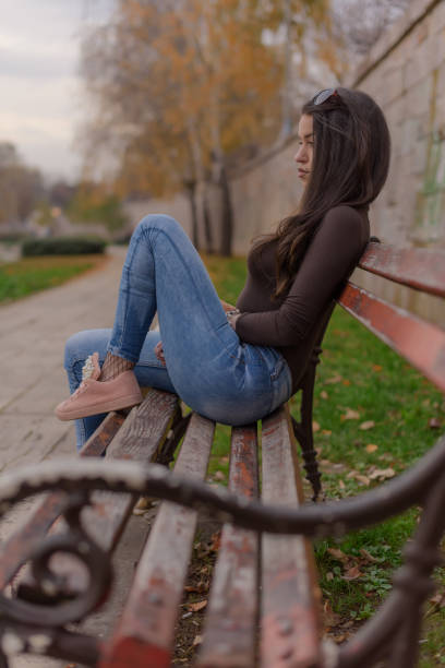 istock A young woman is sitting on a bench 888421050
