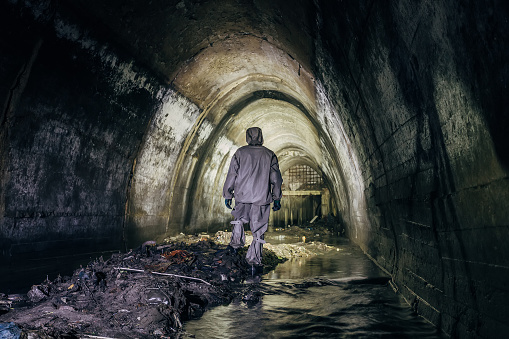 Trabajador de túnel de alcantarillado en suite protección química en túnel subterráneo alcantarilla gaseosa photo