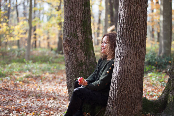 istock woman eating an apple in the woods 888432196