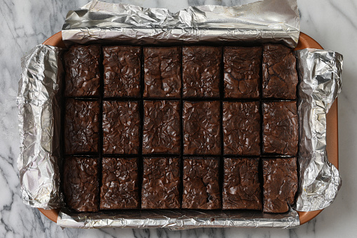 An overhead close up horizontal photograph of freshly baked chocolate brownies cooling off in a baking pan.