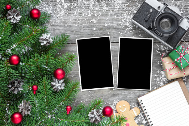 istock retro camera and christmas blank photo frame with fir tree branches, decorations and lined notebook 888470456