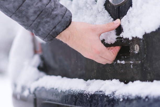 istock Man trying to open frozen car lock 888473056