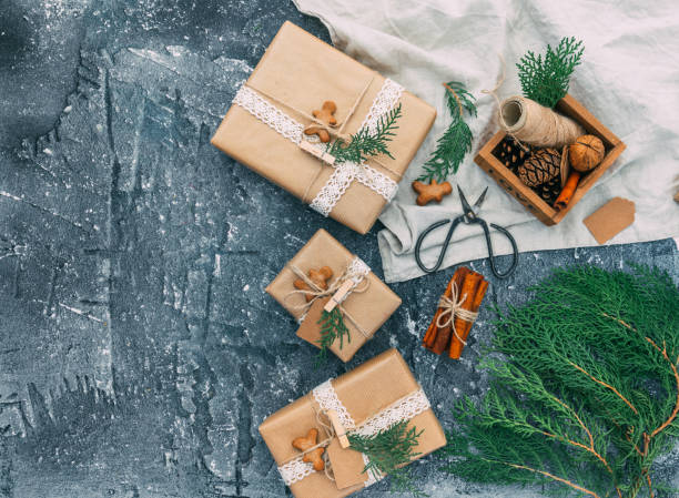 istock Homemade wrapped rustic brown paper packages with various natural things on blue vintage background. Flat lay, top view 888478324