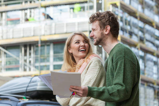 istock Couple with blueprint project keys on construction site 888497826