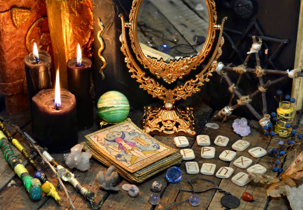Tarot cards, magic wands, runes, black candles with mirror and old book Occult, esoteric, divination and wicca concept. Mystic and vintage background runes photos stock pictures, royalty-free photos & images
