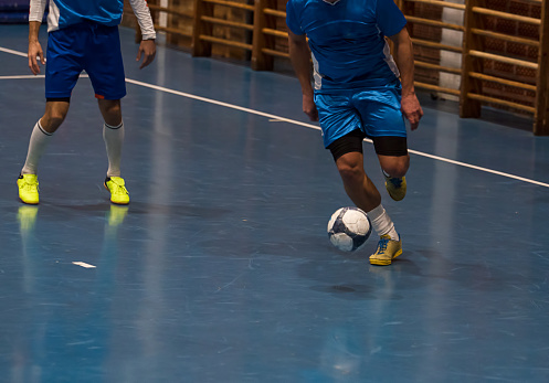 Futsal player with the ball in the sports hall