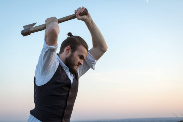 istock Man swinging an ax against the sky 888530150