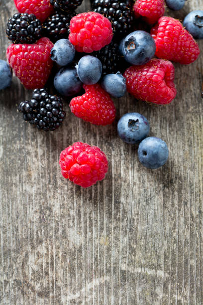 istock summer wild berries on wooden surface 888562846