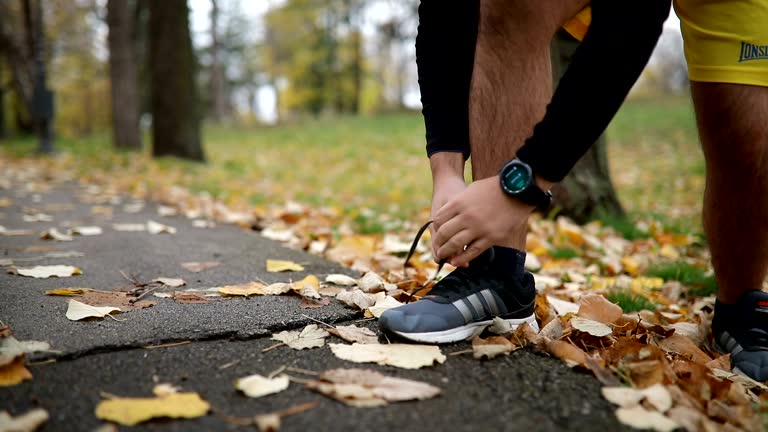 Athlete Wearing Smart Watch While Tying His Shoes