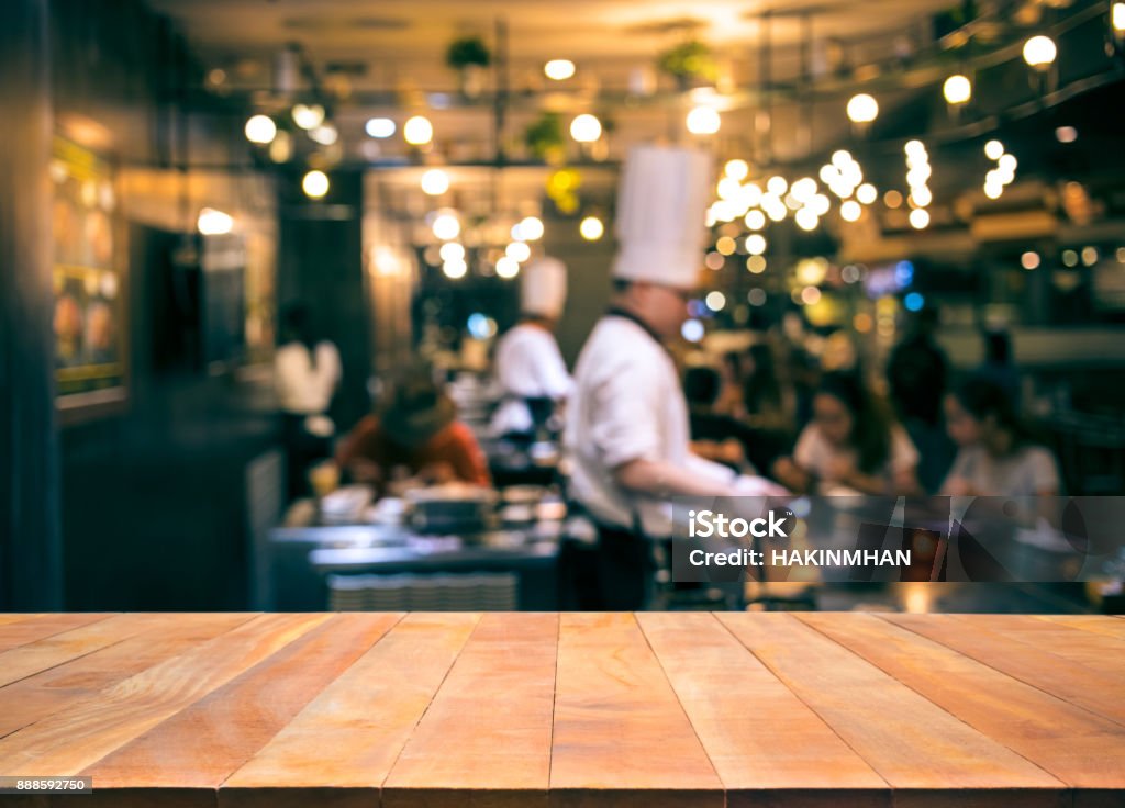 Tabela de madeira superior com borrão chef de cozinha no bar restaurante - Foto de stock de Restaurante royalty-free