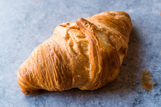 istock Freshly Baked Croissants on Blue Surface. 888609158