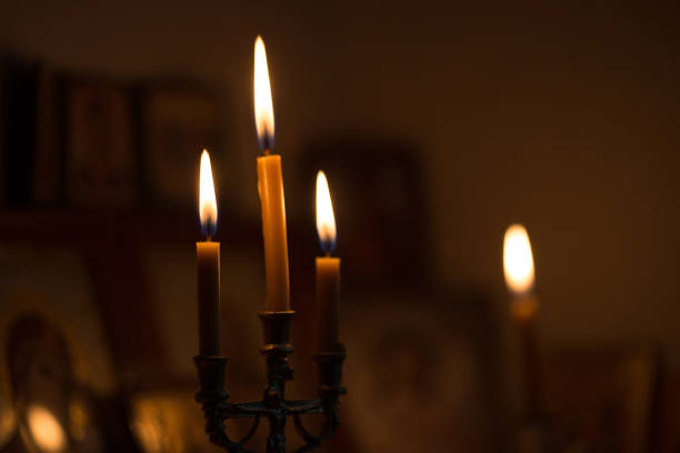 istock burning candle against of orthodox icons 888632196