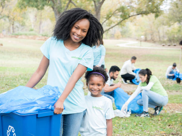 istock Young girl and her mom help clean up community 888633972