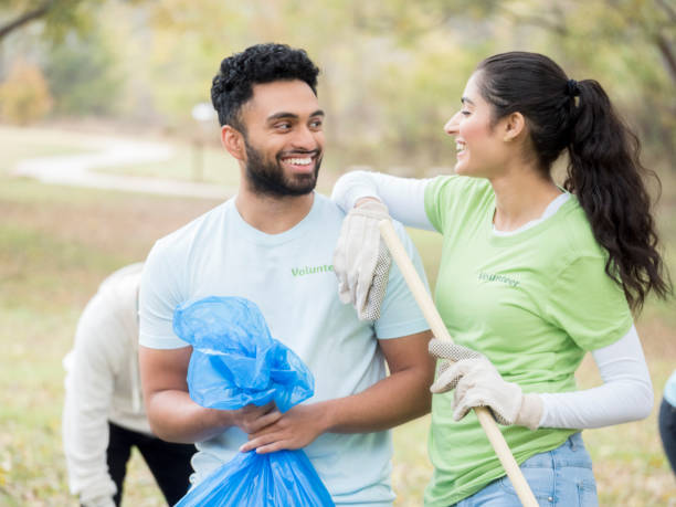 istock Young couple work together during community cleanup 888634040