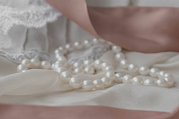 collar de perlas en un tejido hermoso. colores pastel. - pearl jewelry wedding necklace fotografías e imágenes de stock