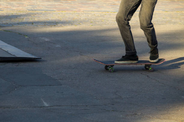 istock Skateboarder legs riding skateboard at skatepark 888660374