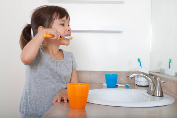 cute girl brushing teeth - dental floss brushing teeth dental hygiene dental equipment imagens e fotografias de stock