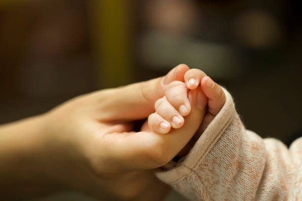 Baby Holding Mothers Hand stock photo