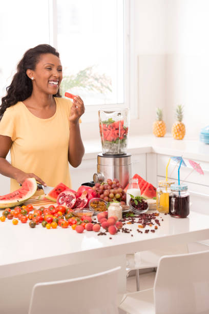 istock Woman making fruit juices at kitchen. 888675158