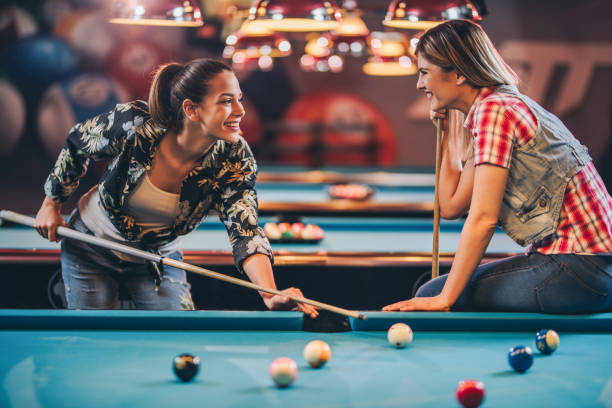 istock Happy female friends talking while playing billiard in a pool hall. 888678150
