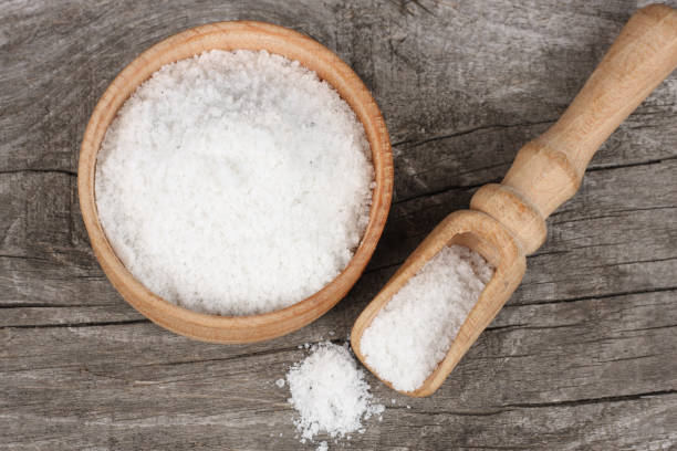 istock salt on wood plate on old wooden table. Top view 888684998