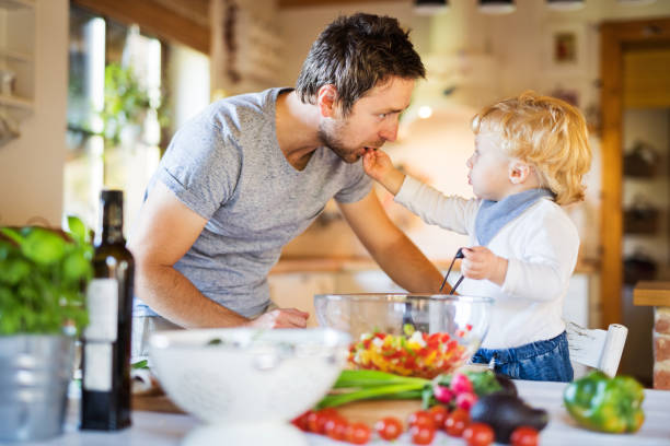 istock Young father with a toddler boy cooking. 888685796