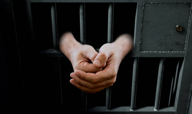 istock Jail Cell Door And Hands 888688586