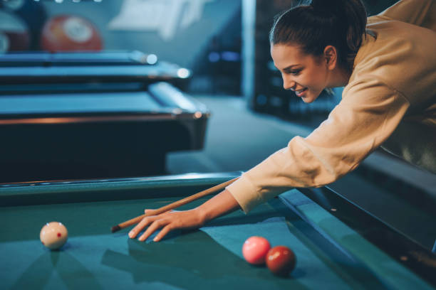 istock Young happy woman playing billiard in a pool hall. 888692126