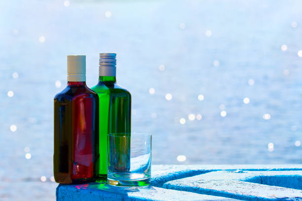 湖の背景にガラスとジン ・ ウイスキーのボトル - gin decanter whisky bottle ストックフォトと画像