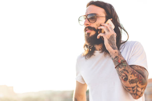 istock Hipster tattooed rebel guy using mobile phone 888698700