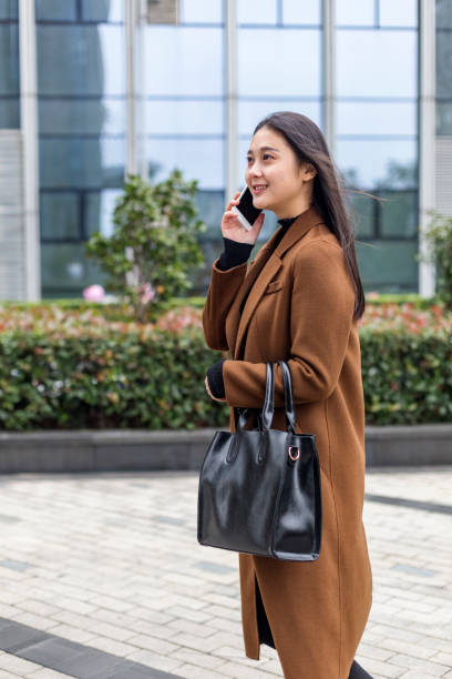 istock young woman talking on cellphone by office building 888699252